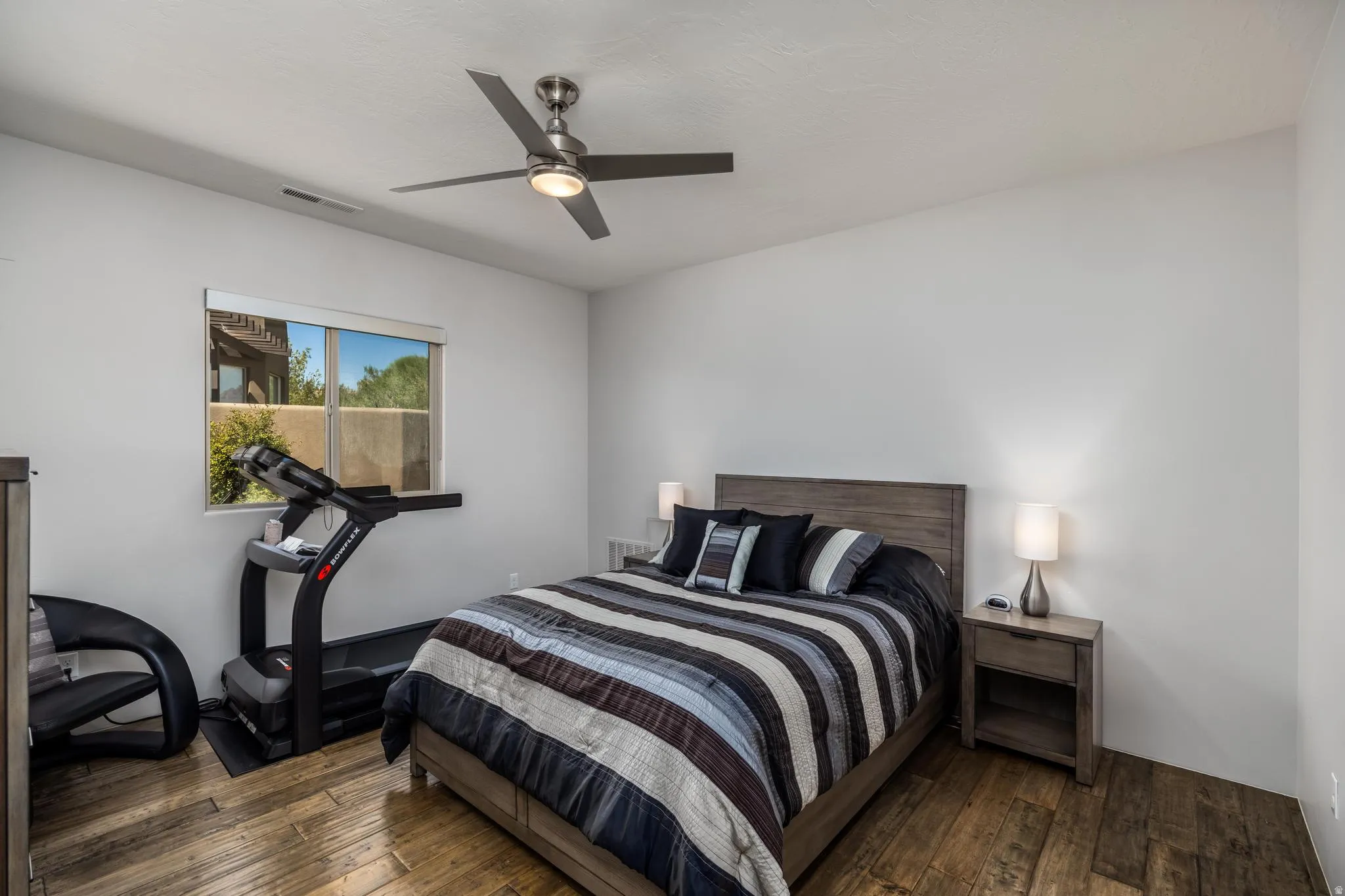 Window with exterior scenery, wood-finish flooring, and a ceiling fan with integrated lighting