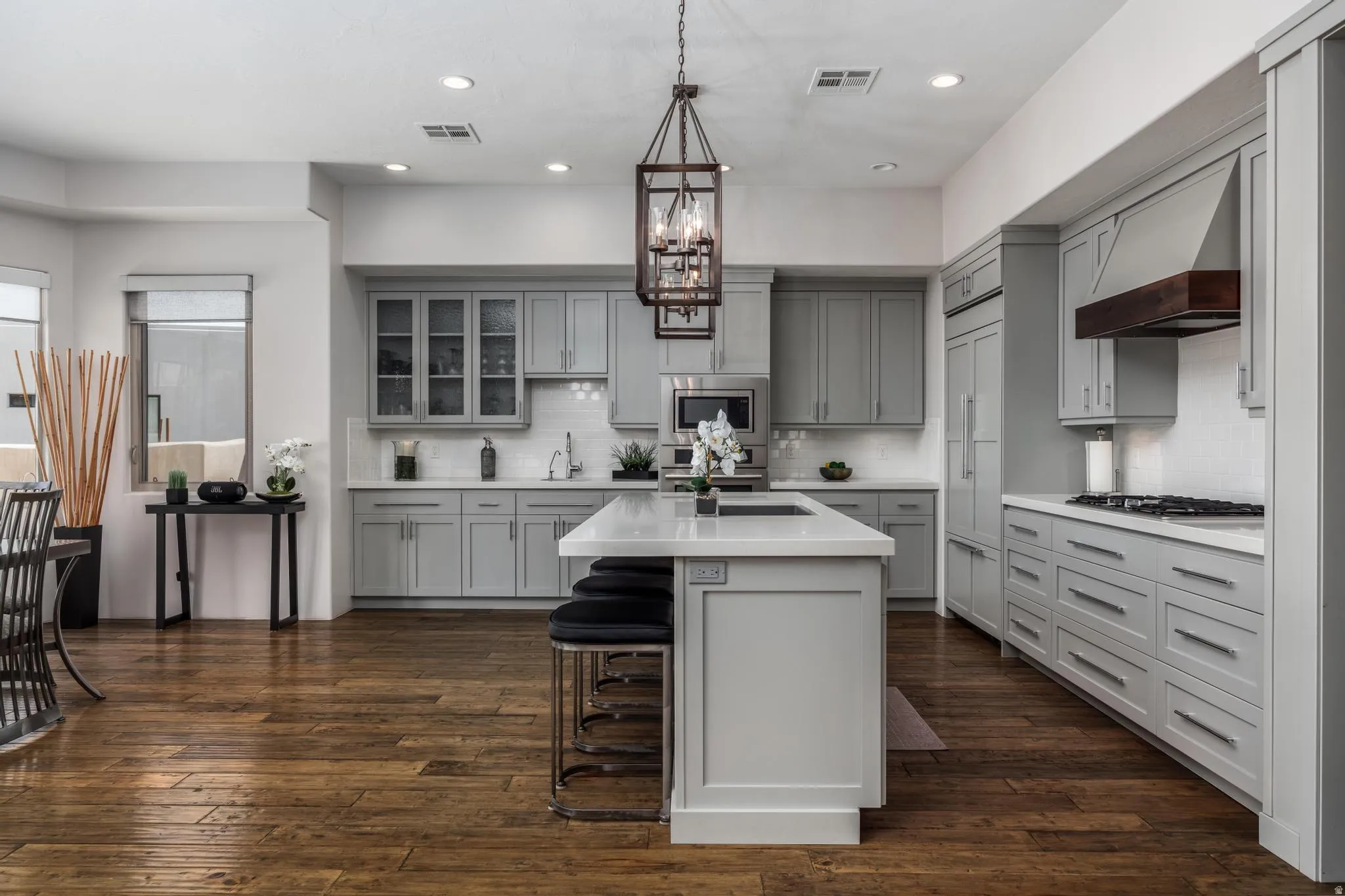 Spacious kitchen featuring an island, light gray cabinetry, white countertops, wood-finish flooring, and recessed lighting