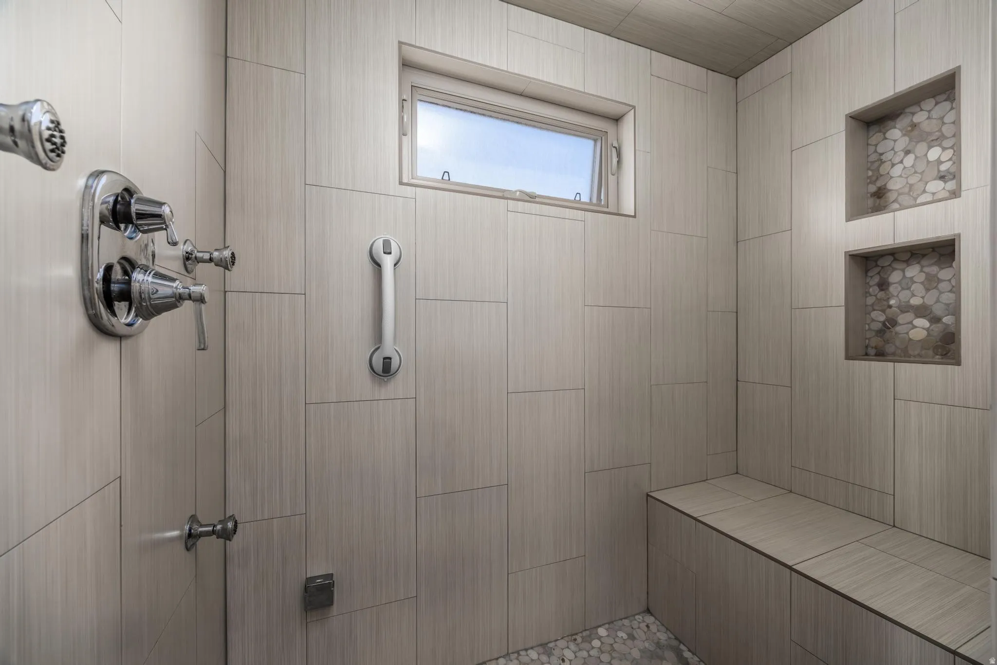 Tiled shower with a built-in bench, two tiled niches, and a window/ Steam Shower Primary Bathroom