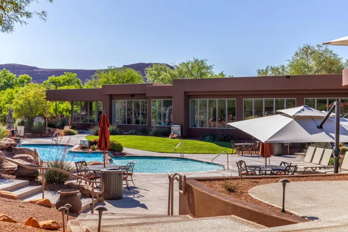 Expansive outdoor common area featuring a multi-level pool, substantial lounging space, and mature landscaping
