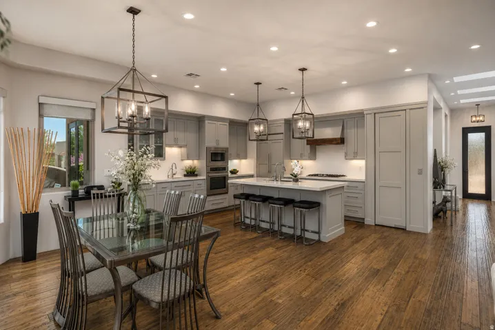 Open-concept kitchen and dining area featuring wood-finish flooring, recessed lighting, and a kitchen island with seating