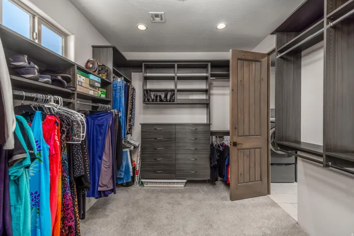 Primary Walk in Closet. Custom closet organization system featuring built-in shelving, hanging rods, and integrated drawer units