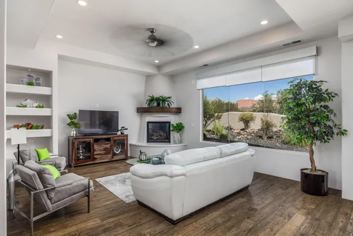 Recessed lighting, wood-finish flooring, corner fireplace with wood mantel, built-in shelving, and a large picture window