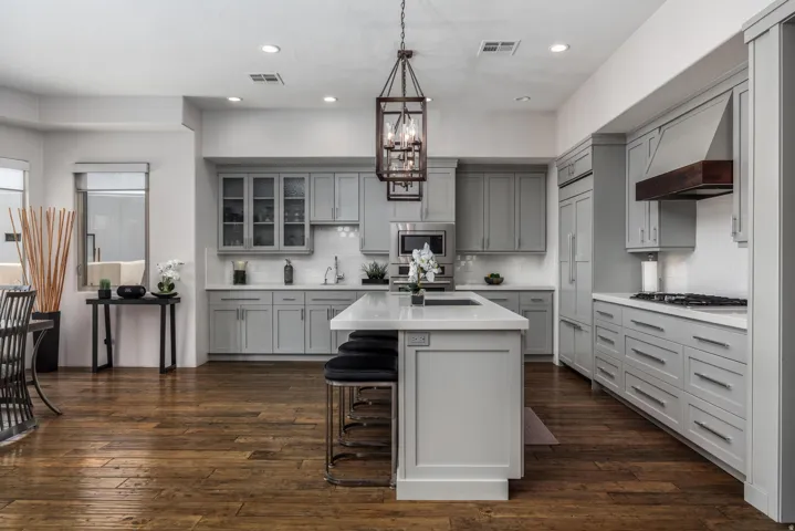 Spacious kitchen featuring an island, light gray cabinetry, white countertops, wood-finish flooring, and recessed lighting