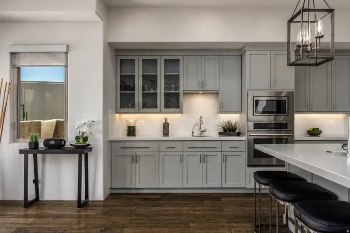 Kitchen featuring grey shaker cabinetry, stainless steel appliances, white subway tile backsplash, and wood-finish flooring