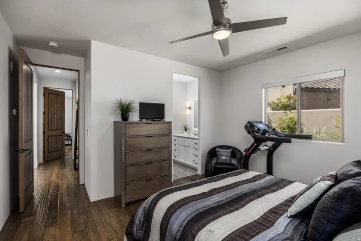 Wood-finish flooring throughout, ceiling fan with integrated lighting, and a window with exterior views
