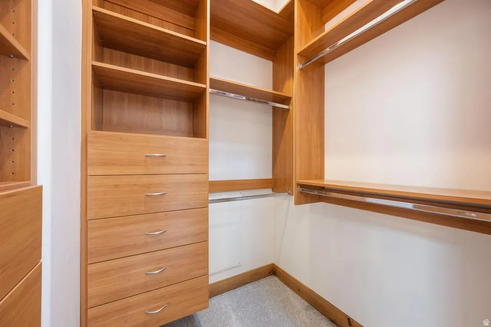 Custom wood-finish cabinetry with drawers, adjustable shelving, and integrated hanging rods