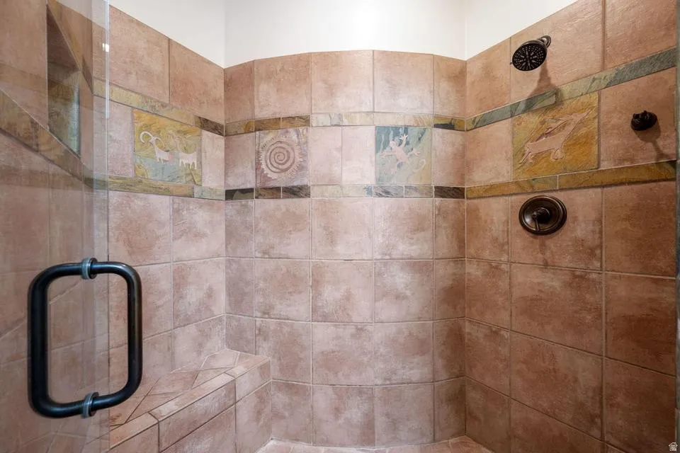 Tiled walk-in shower with a built-in bench, glass enclosure, and decorative accent tiles