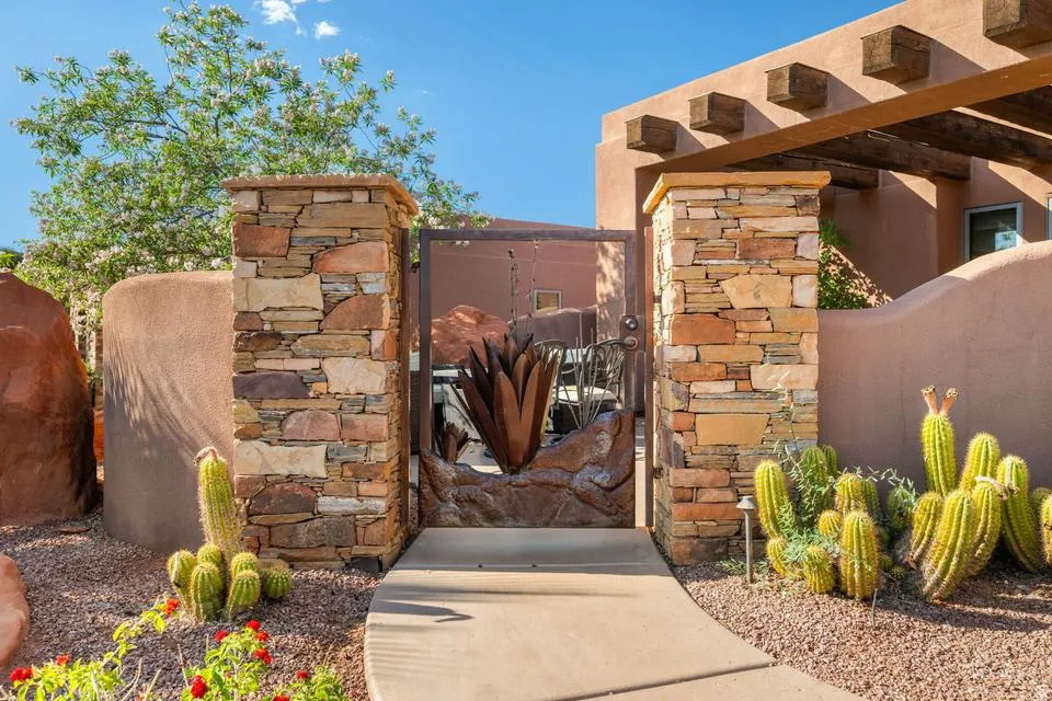 Stone pillar entry gate featuring a decorative metal insert