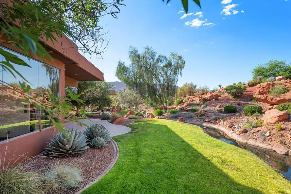 Expansive green lawn with a natural water feature