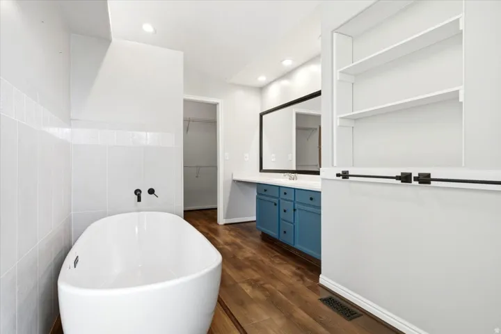 Freestanding soaking tub with wall-mounted fixtures