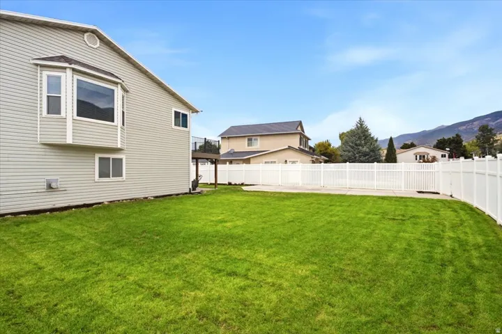 Expansive lawn area with a white privacy fence