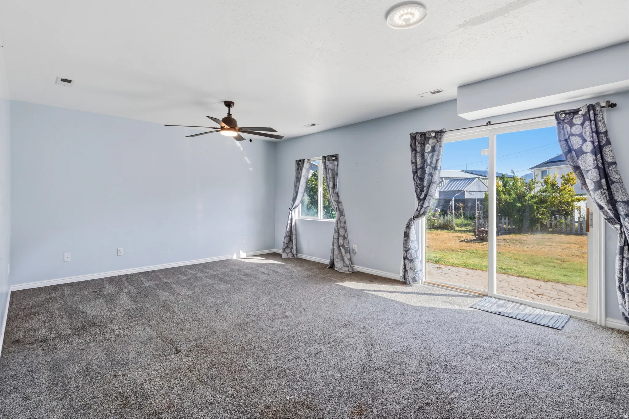 Expansive room featuring a ceiling fan, recessed lighting, and soft gray carpeting