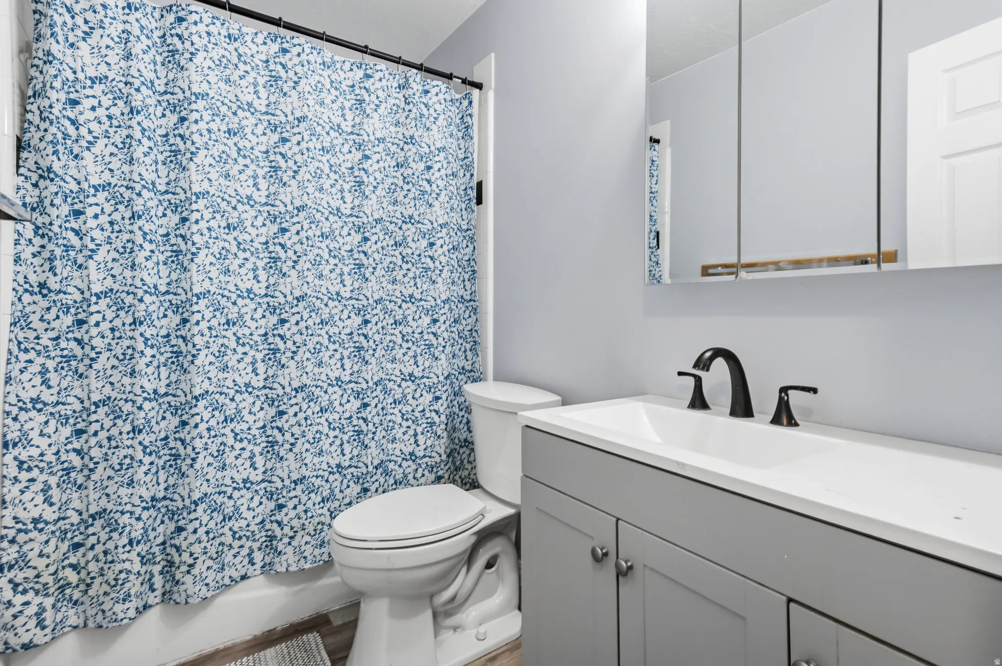 Bathroom featuring a vanity with a white countertop, undermount sink, and matte black faucet