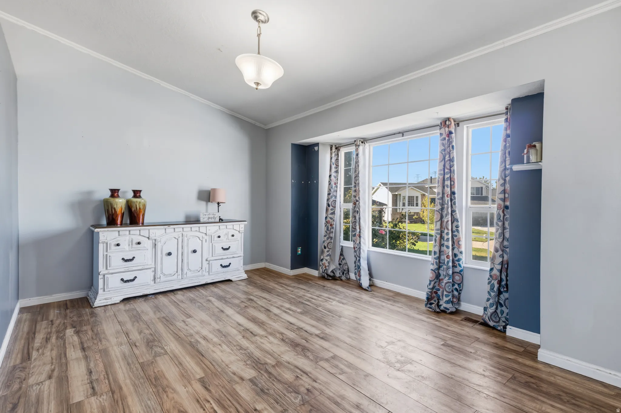 Wood-finish flooring with an angled ceiling and crown molding