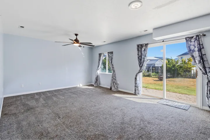 Expansive room featuring a ceiling fan, recessed lighting, and soft gray carpeting