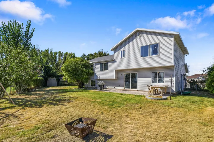 Expansive backyard with a large lawn area and mature perimeter trees