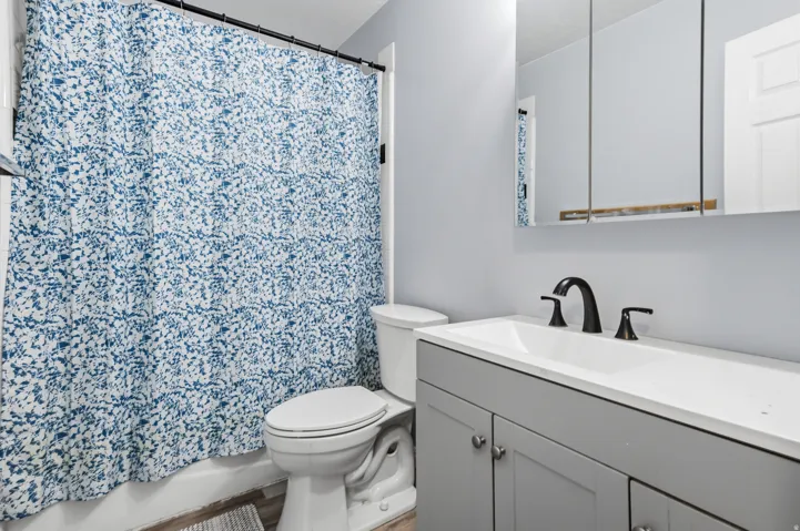 Bathroom featuring a vanity with a white countertop, undermount sink, and matte black faucet