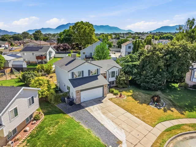 Two-story residence featuring a two-car garage, concrete driveway, and established landscaping