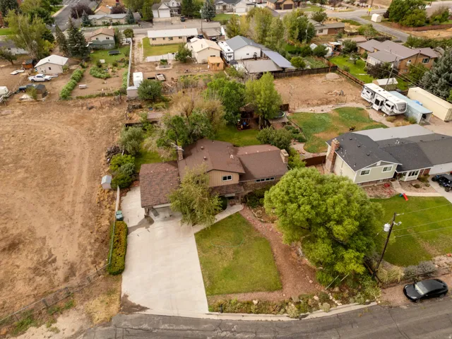 Property exterior with a brown shingle roof, attached garage, and concrete driveway