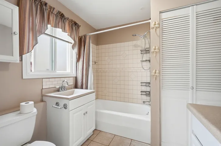 Built-in vanity with integrated sink, white cabinetry, and polished chrome fixtures