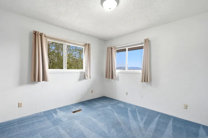Recessed ceiling light fixture, white walls, and blue patterned carpet