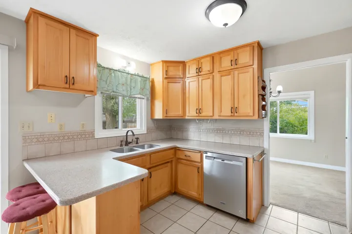 Maple cabinetry, light-toned countertops, and a tile backsplash