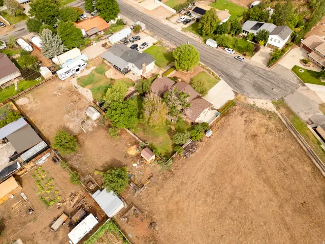 Expansive lot featuring multiple structures, mature trees, and direct road access