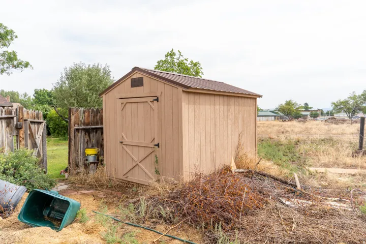 Wood-sided storage shed with a metal roof and double doors