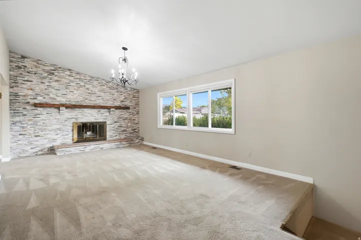 Stacked stone fireplace with a wood mantel
