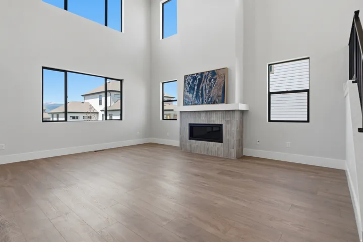 Double-height ceiling, abundant natural light,  tiled fireplace surround, black metal stair railing