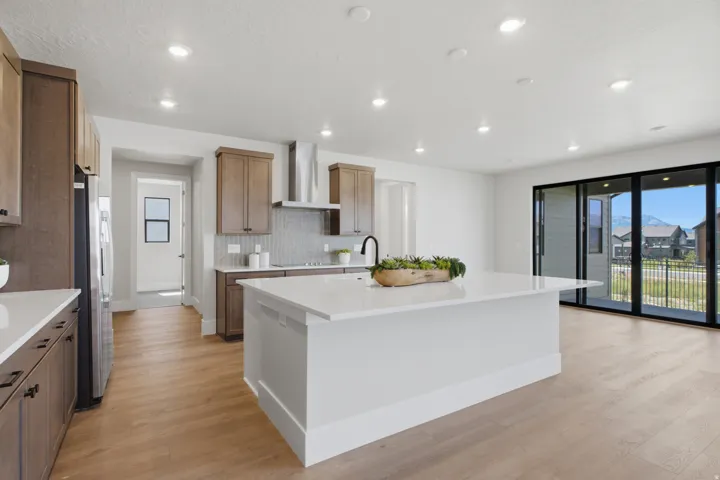 Open-concept kitchen with a large central island, stainless steel appliances, and expansive sliding glass doors