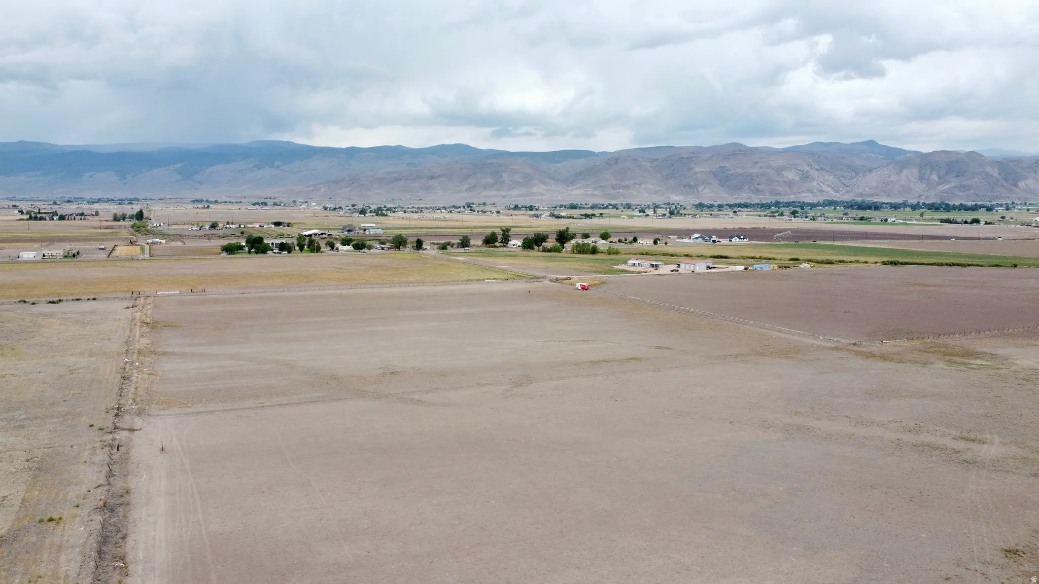 Expansive open land featuring distant mountainous terrain