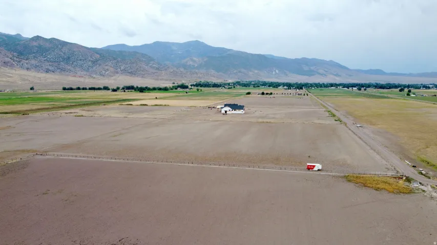 Expansive land parcel featuring a contemporary single-story residence with a dark roof and a paved access road