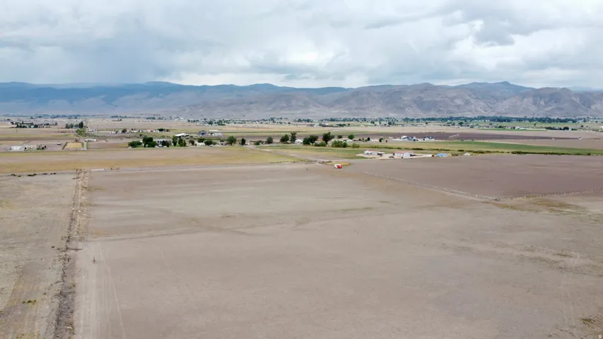 Expansive open land featuring distant mountainous terrain