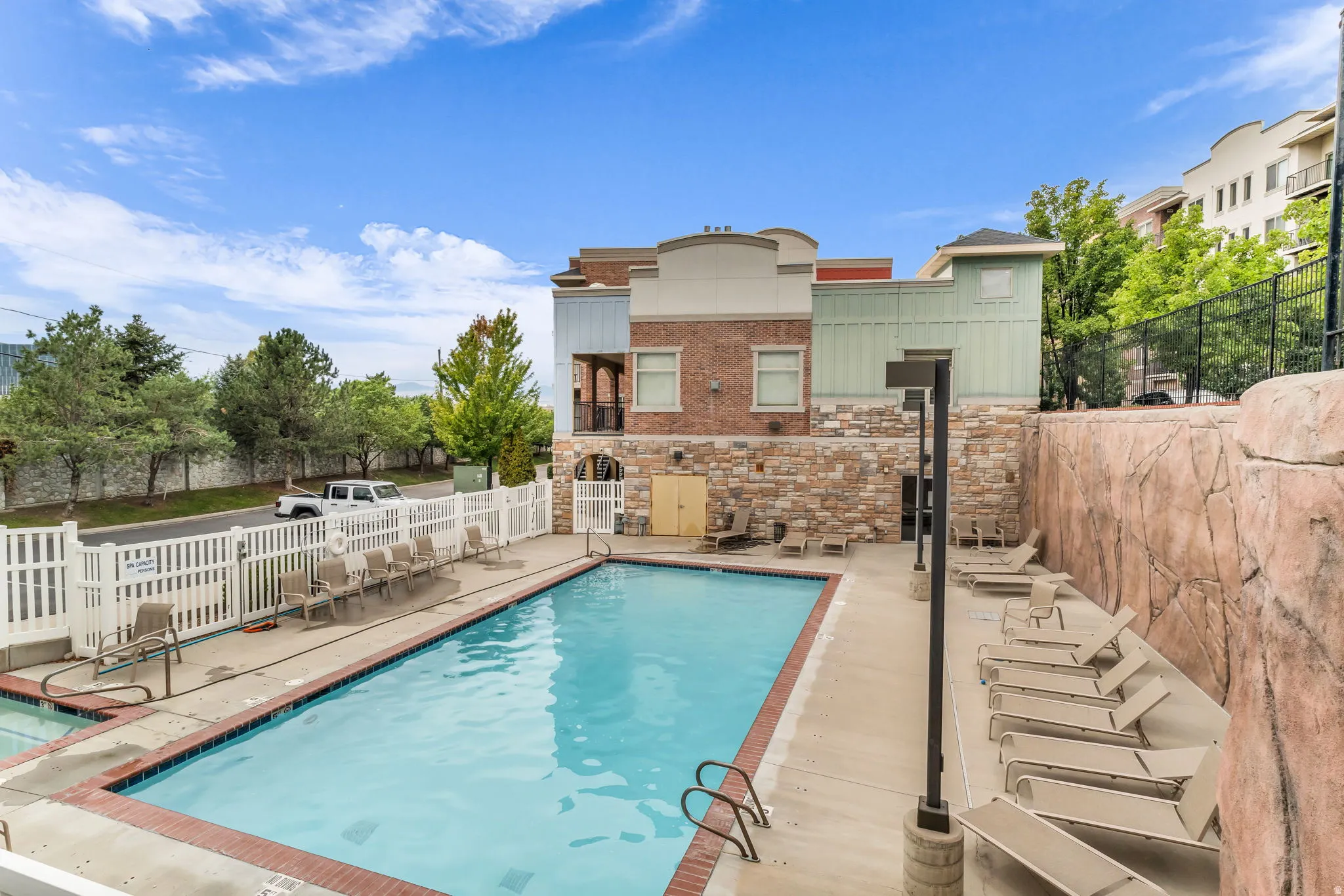 Outdoor swimming pool with integrated steps and a white picket fence surround