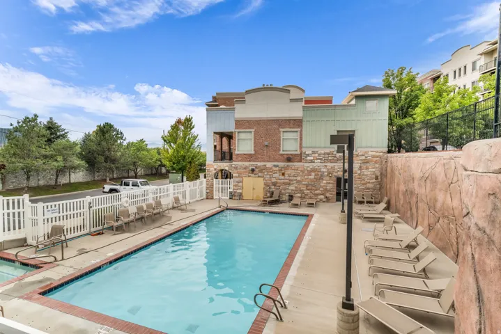 Outdoor swimming pool with integrated steps and a white picket fence surround