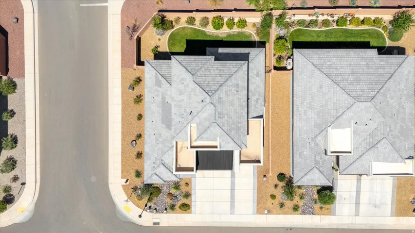 Paved street with concrete curbing, bordered by desert landscaping
