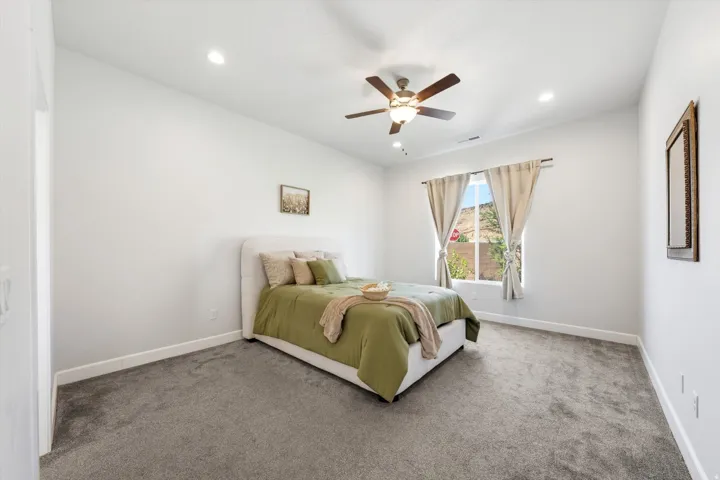 Neutral wall tones, recessed lighting, ceiling fan, and carpeted flooring
