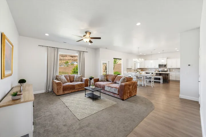 Open-concept living area with recessed lighting, ceiling fan, and large windows