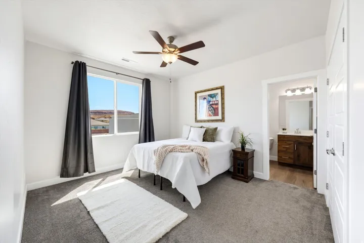 Ceiling fan with light fixture, carpeted flooring, white interior walls, and an attached three-panel door