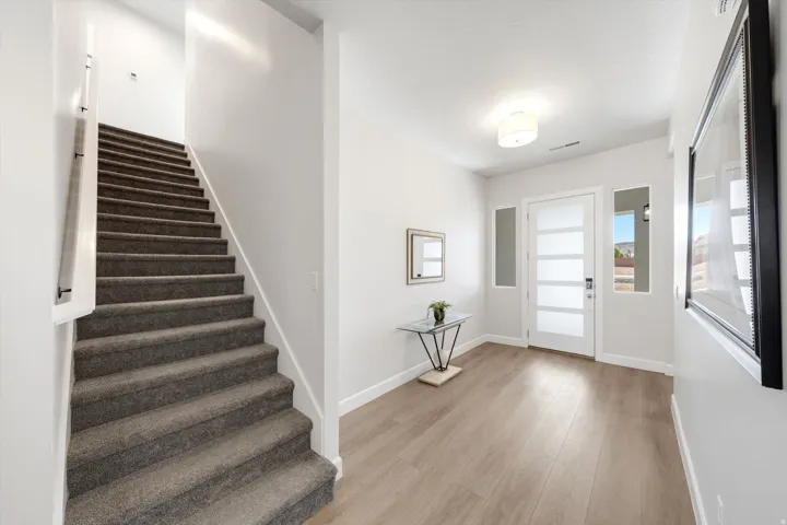 Entryway featuring wood-finish flooring, a white paneled door with horizontal frosted glass inserts, and a flush-mount ceiling light