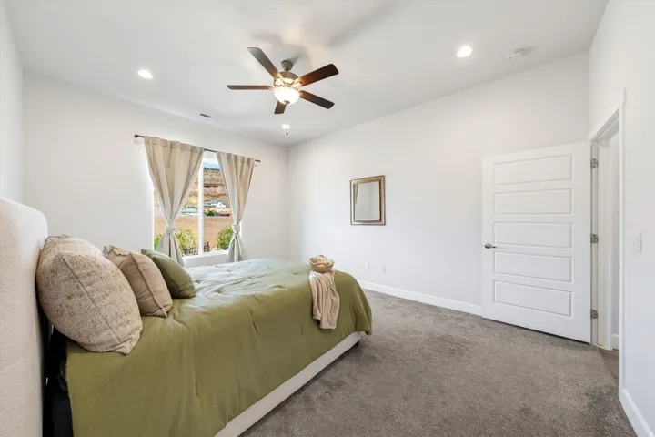 Recessed lighting, ceiling fan with integrated light, carpeted flooring, and a modern five-panel door