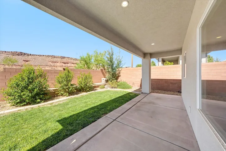 Covered patio with recessed lighting, concrete flooring, and a landscaped yard