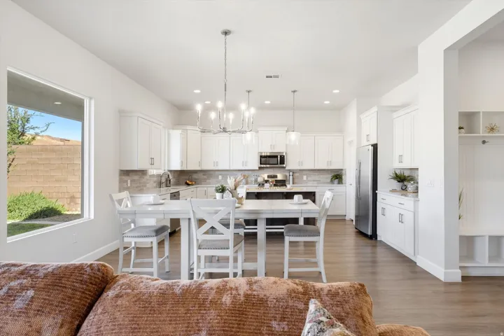 Open-concept kitchen with white cabinetry, stainless steel appliances, and a central island