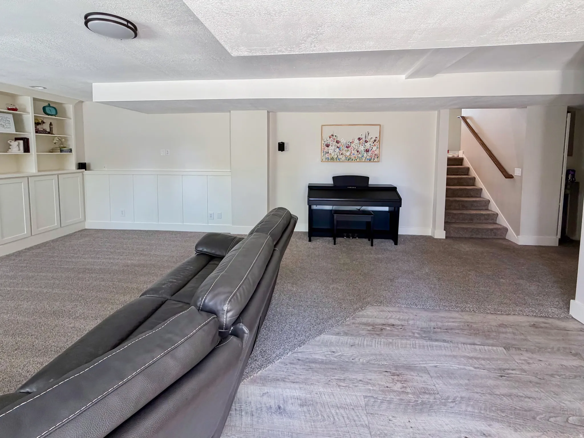 Recessed lighting, built-in cabinetry, wainscoting, wood-finish flooring, and carpeted stairs