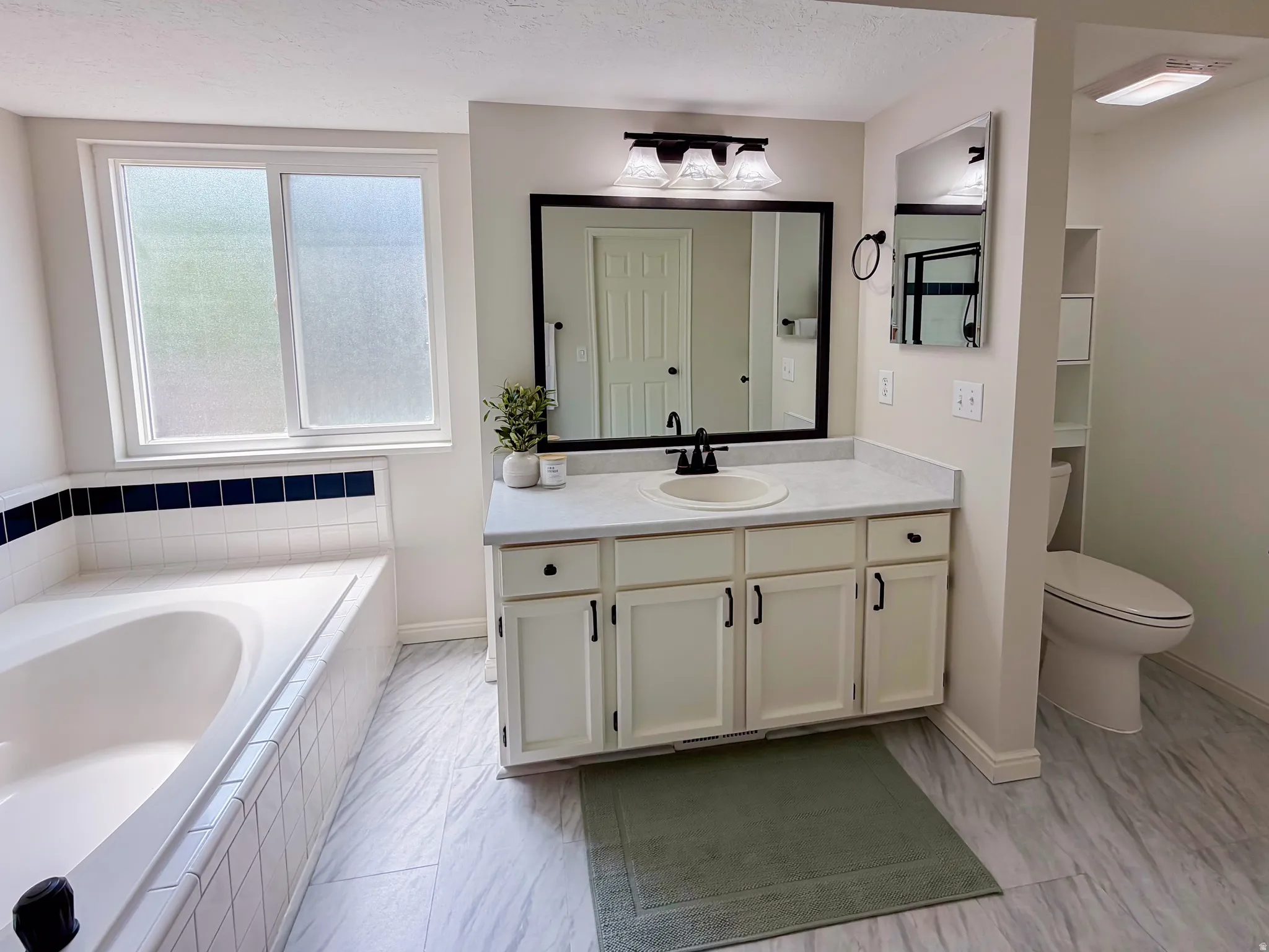 Soaking tub with white and navy tile surround