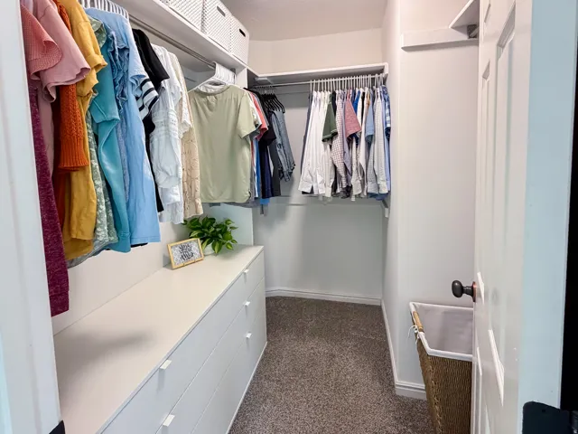 Walk-in closet featuring built-in shelving, hanging rods, and integrated drawer storage
