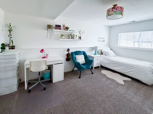 Recessed window with horizontal blinds, neutral wall color, built-in shelving, white trim, and carpeted flooring