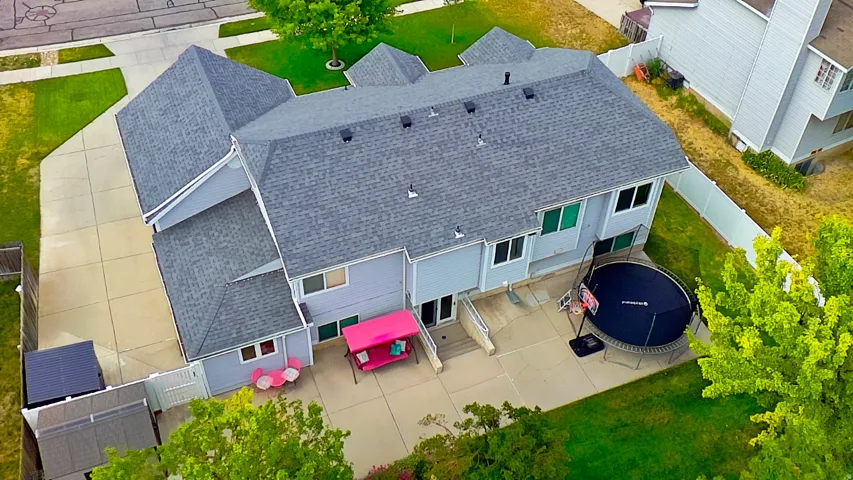 Spacious concrete patio with direct access to interior, fenced backyard, and mature landscaping